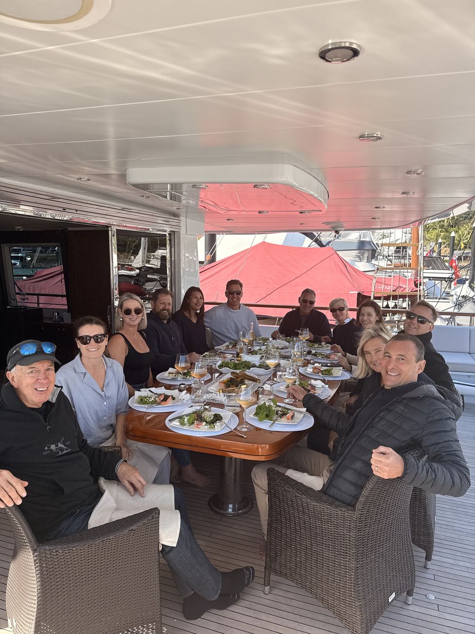 The group at a long lunch table on the aft deck in the marina