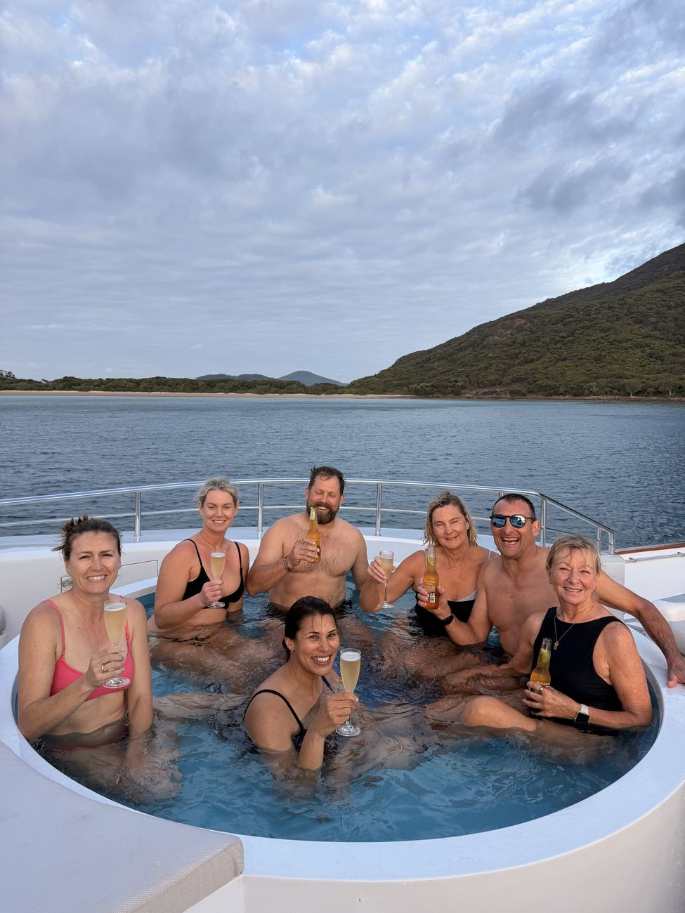 Guests in the bow spa with champagne, Shaw Island behind
