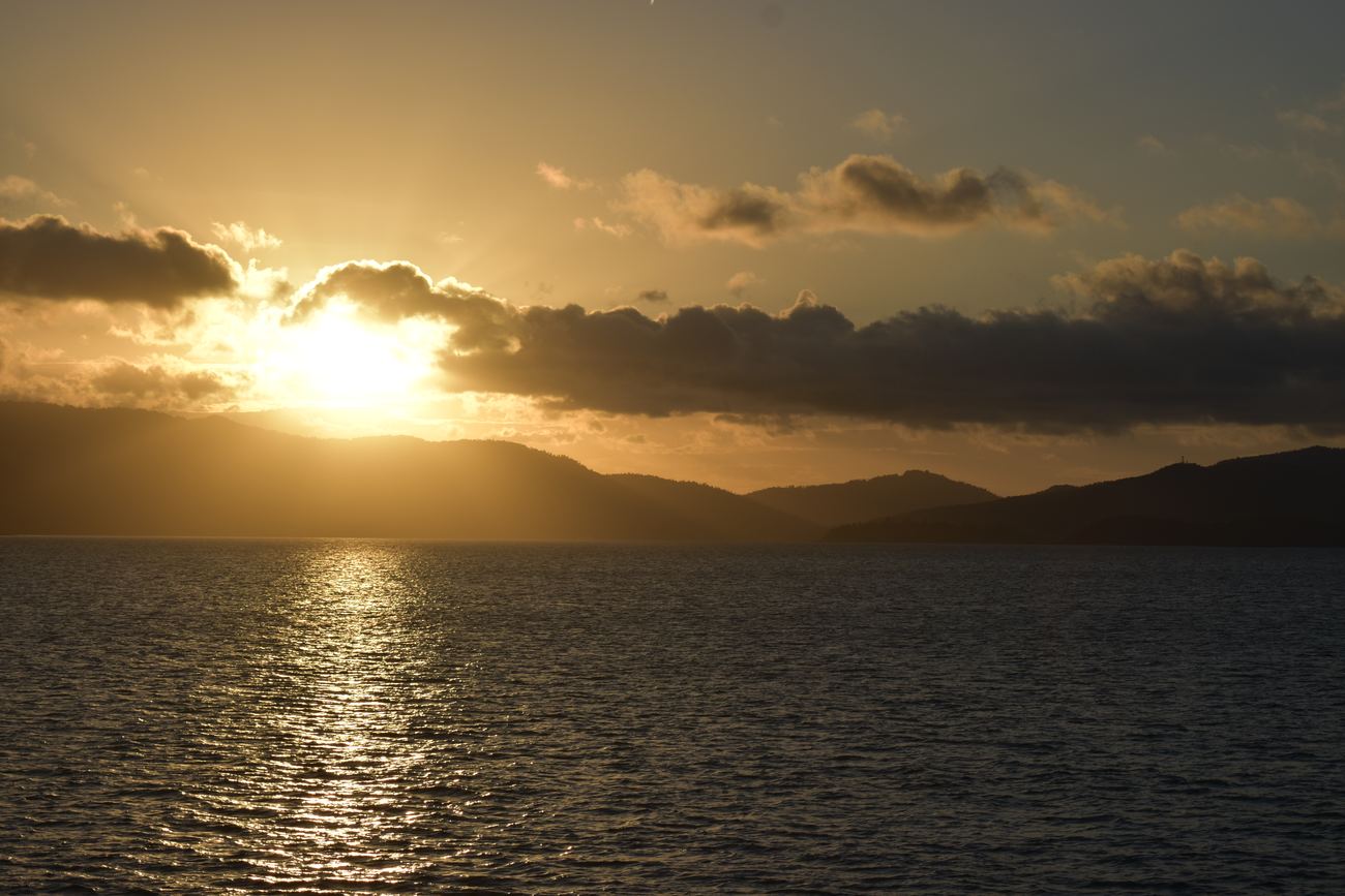 The sun setting over layered islands, gold across the water