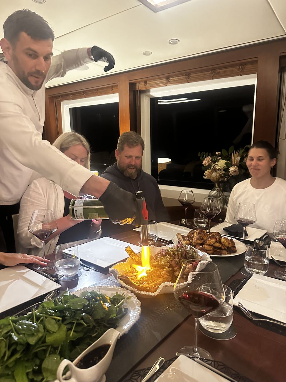 Flame over the platter as the table looks on