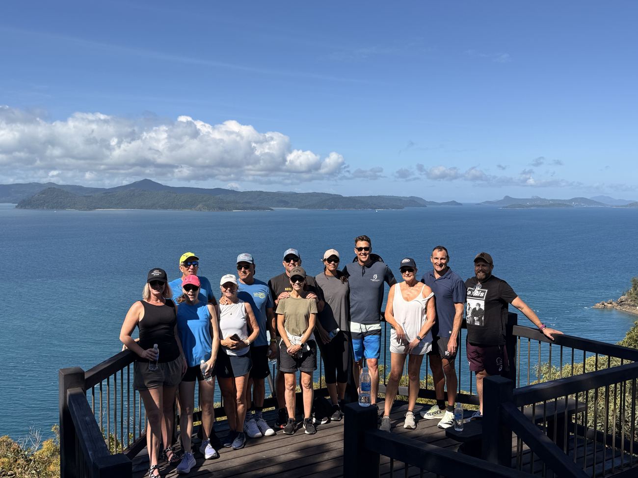 The whole group on the summit platform, islands behind