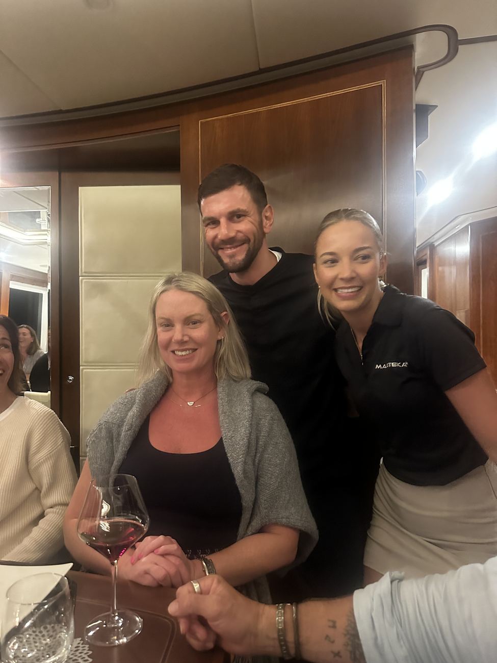 Two crew members with a guest at dinner