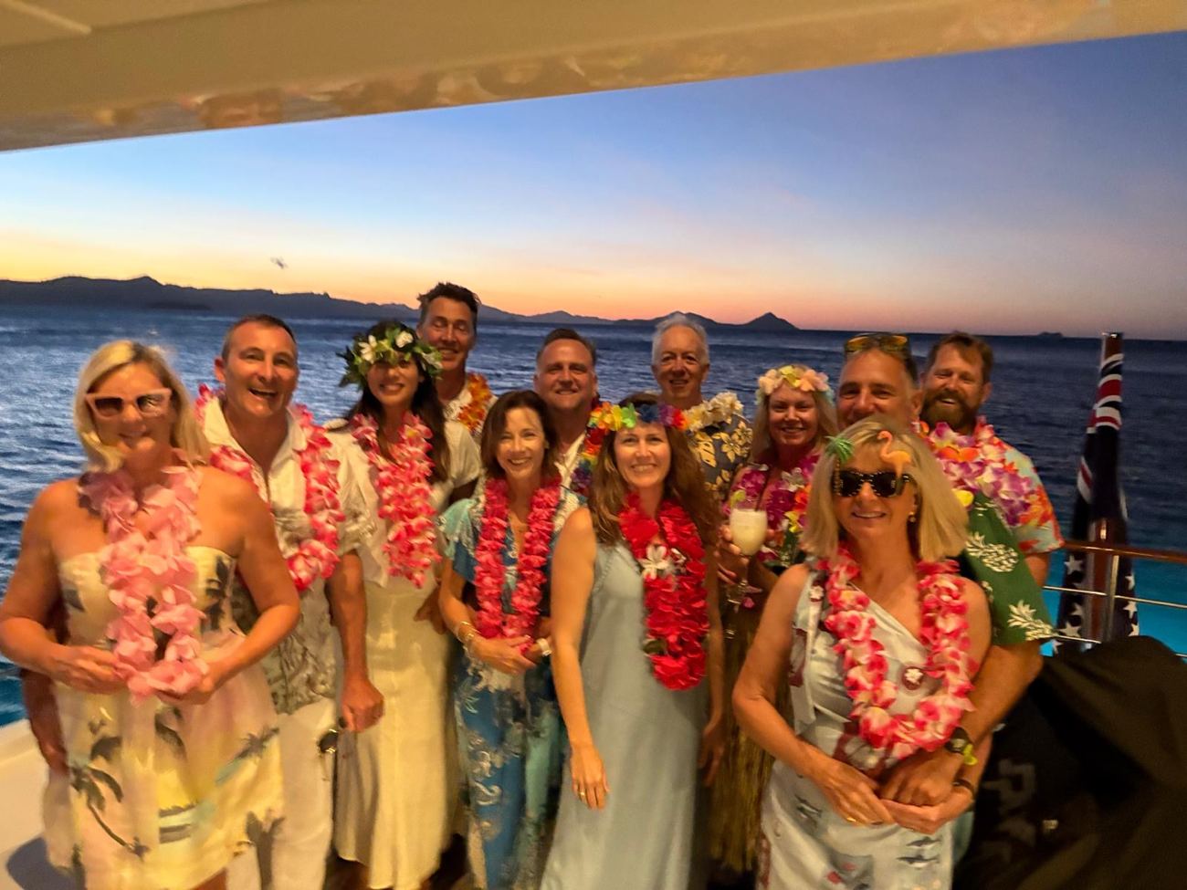 The full company in leis at sunset