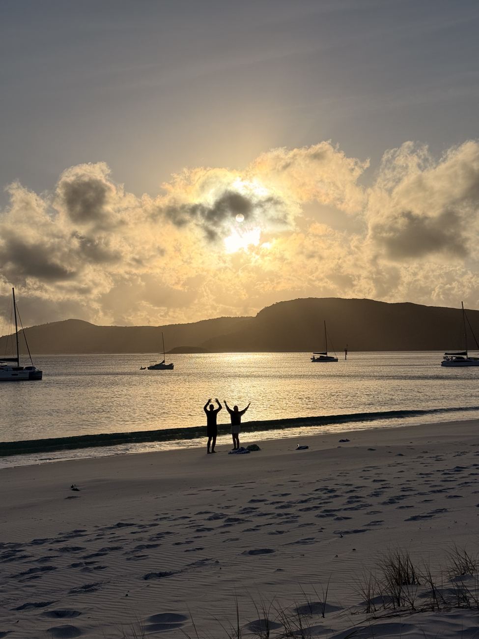 Two figures leap at dawn on Whitehaven Beach