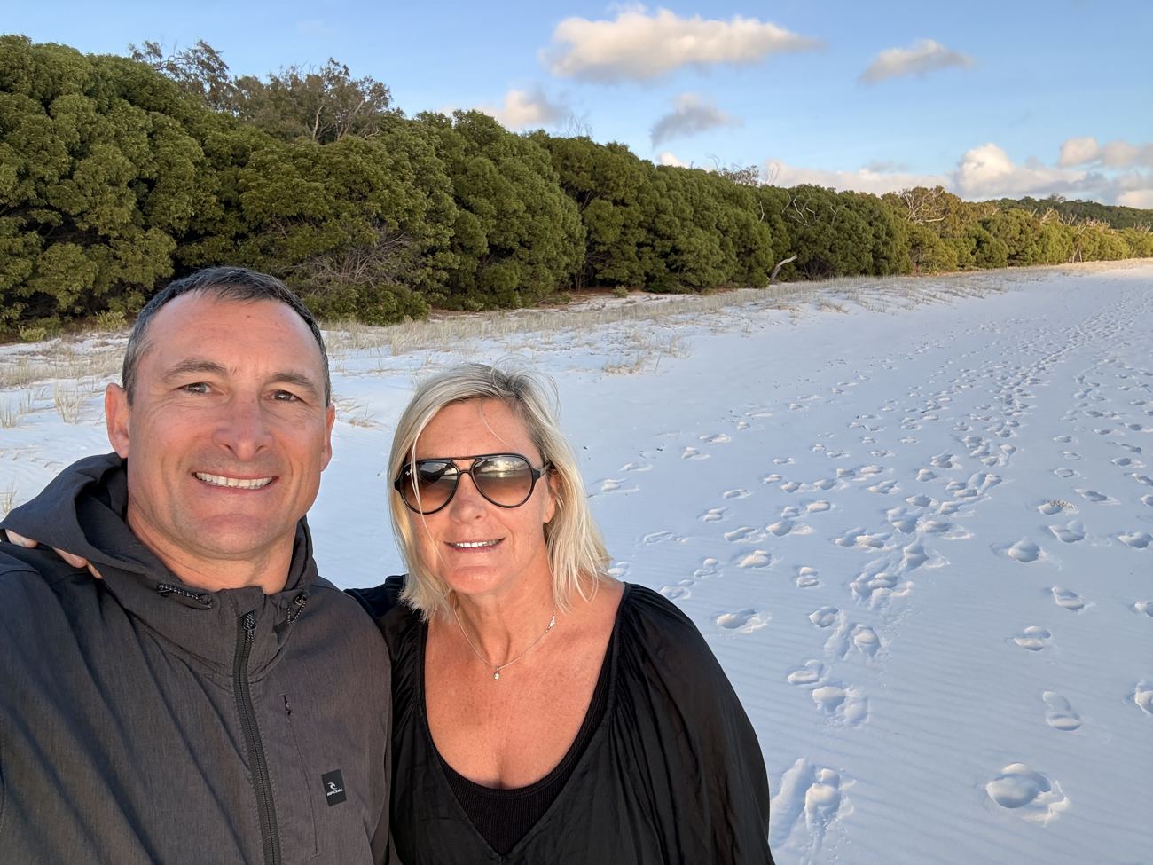 Two walkers on the empty beach at dawn