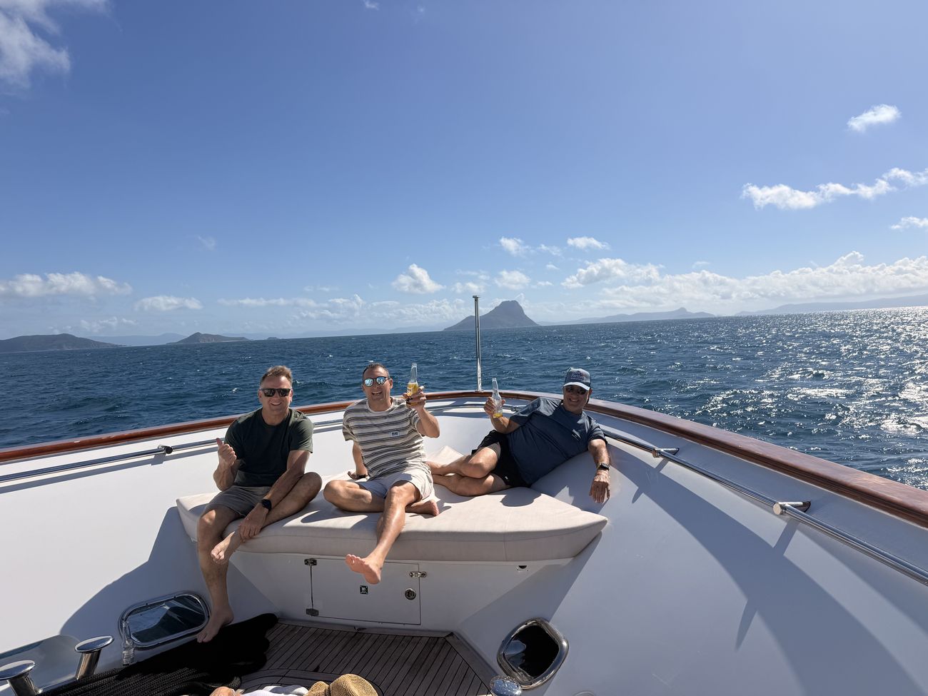 Two guests lounging on the bow underway