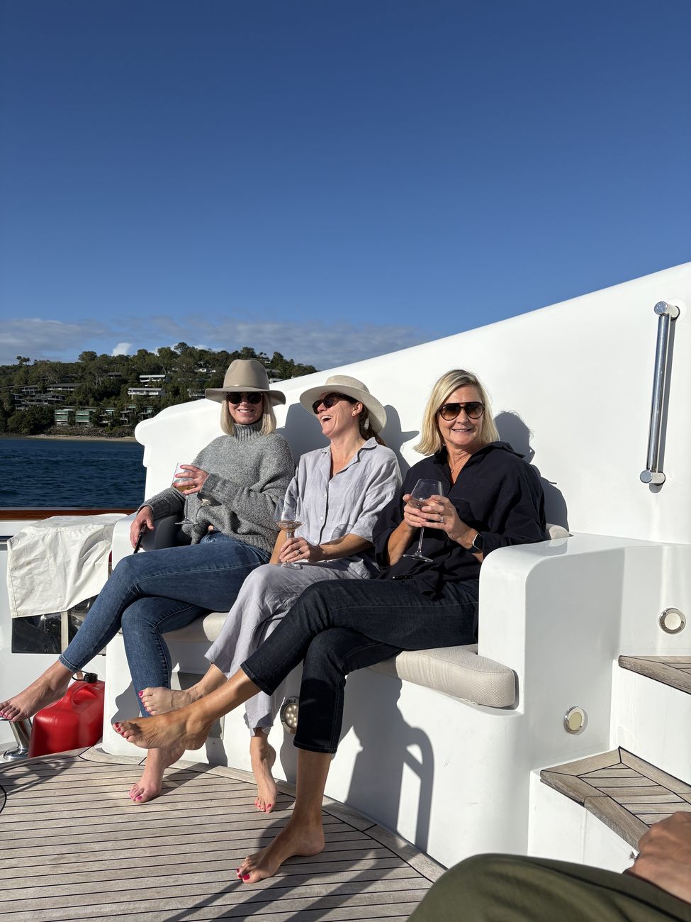 Three guests with wine on the deck bench